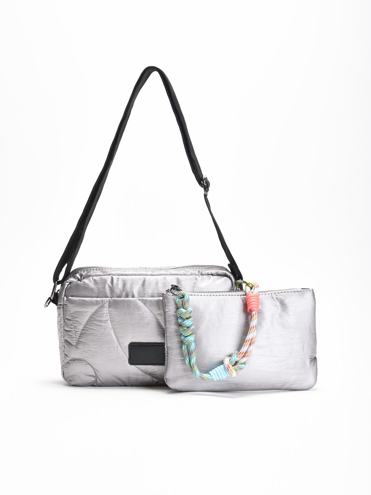 Bolso bandolera acolchado en color gris con correa ajustable negra y neceser extraíble a juego con asa trenzada multicolor.