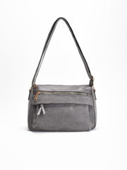 Bolso bandolera gris con solapa, asas medias y varios bolsillos con cremallera. Interior forrado con compartimentos organizadores.