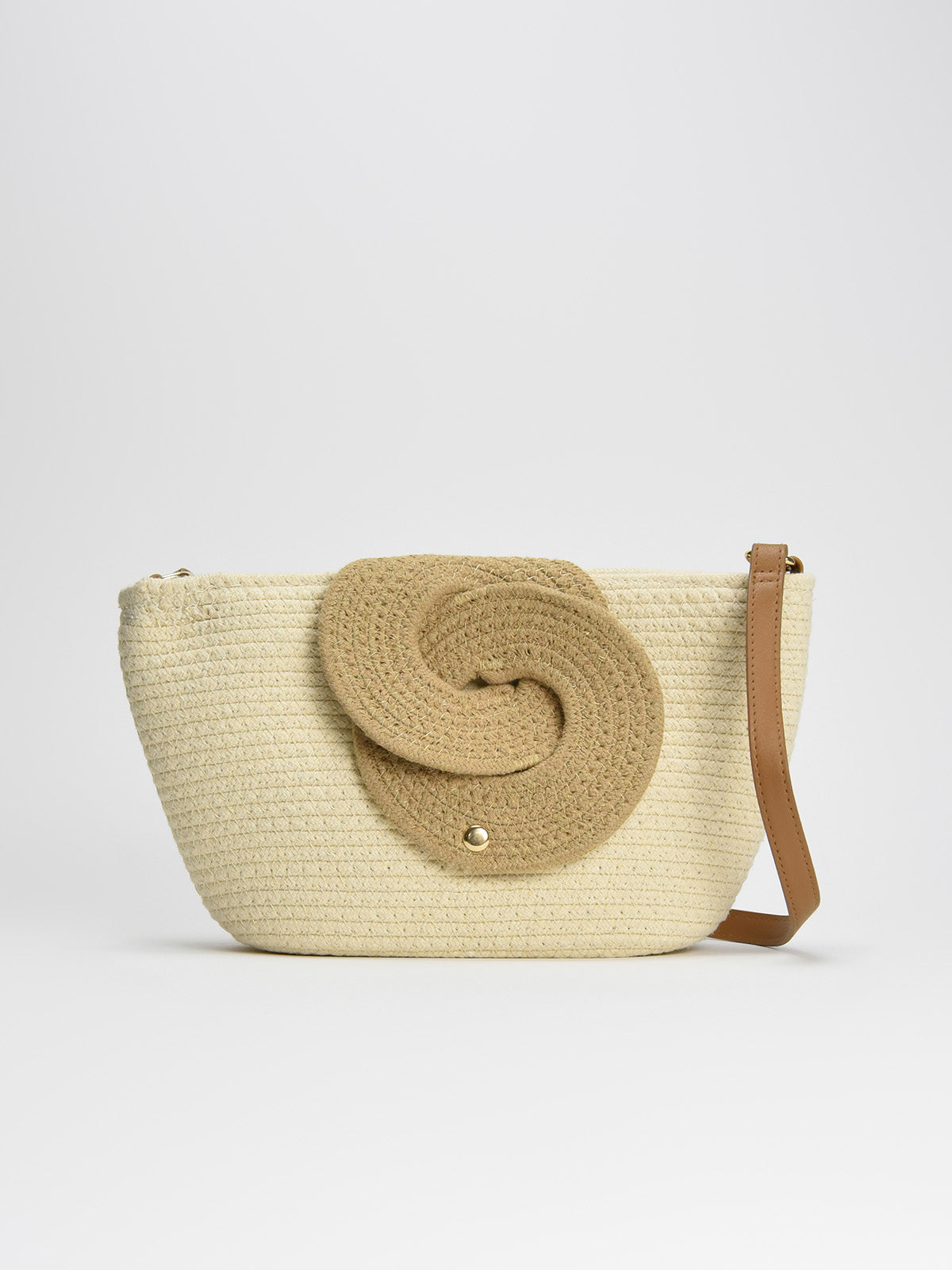 Bolso de rafia beige con detalle espiral y correa ajustable de piel marrón, diseño original y práctico.
