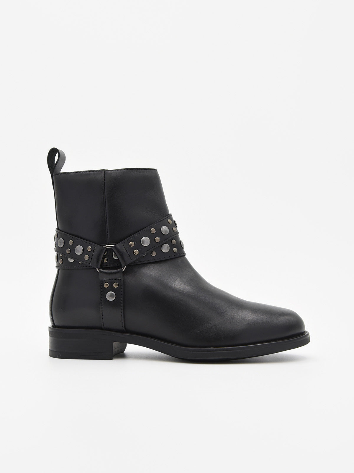 Botín de piel negro con correas decoradas con tachuelas metálicas y cremallera lateral. Tacón bajo, estilo rock chic elegante.
