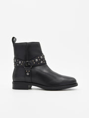 Botín de piel negro con correas decoradas con tachuelas metálicas y cremallera lateral. Tacón bajo, estilo rock chic elegante.