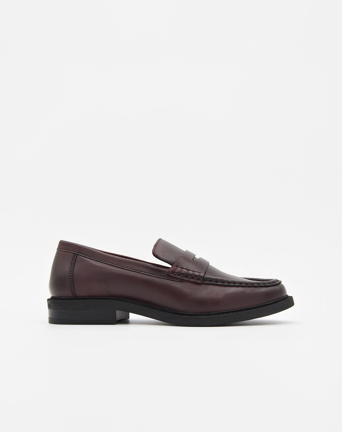 Mocasín de piel burdeos para mujer, estilo clásico con antifaz en el empeine y suela negra.