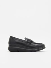 Mocasín de piel negra para mujer, con suela cómoda y adorno metálico en el empeine.